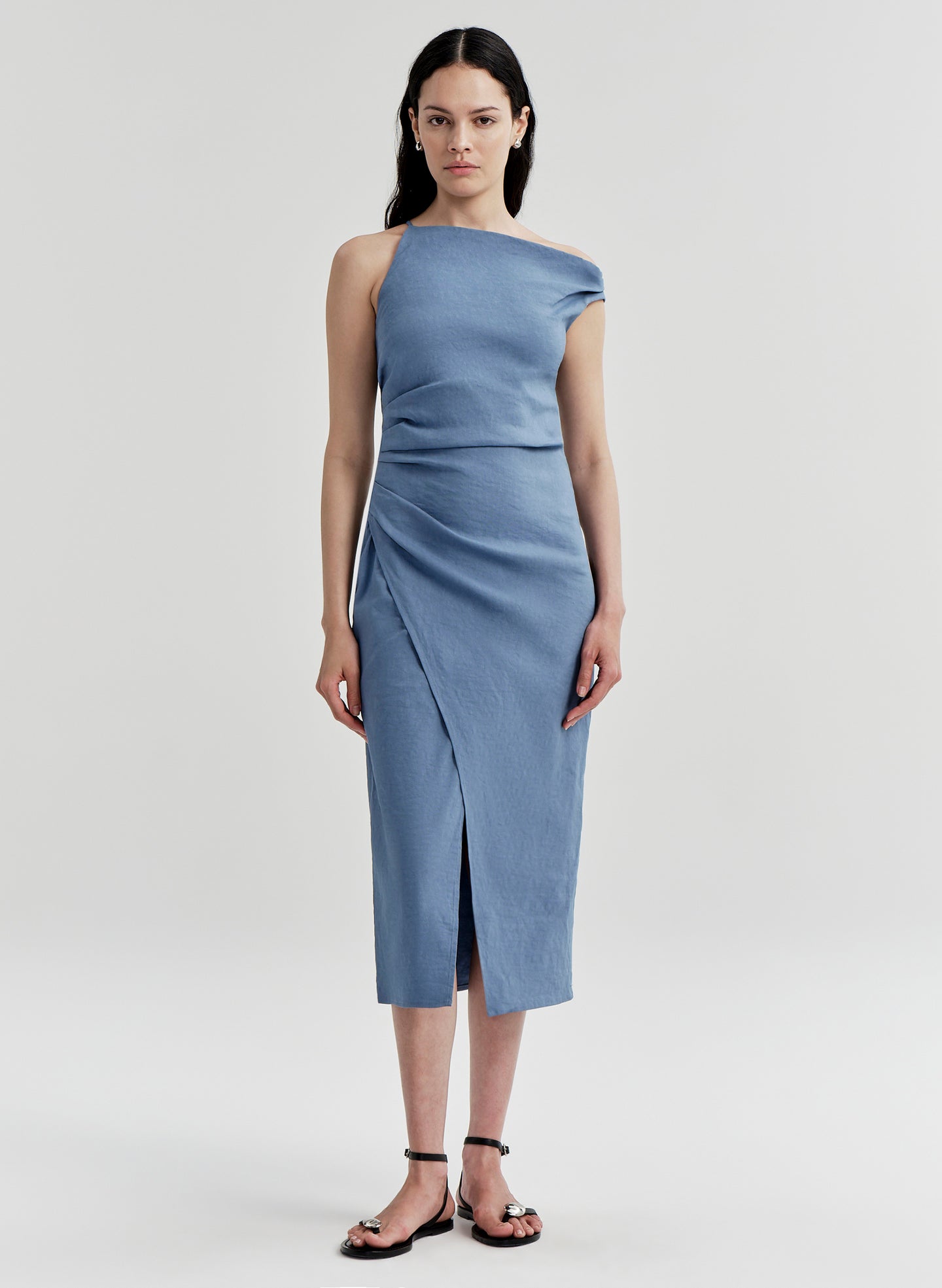 Woman wearing a blue one-shoulder dress on a light gray background