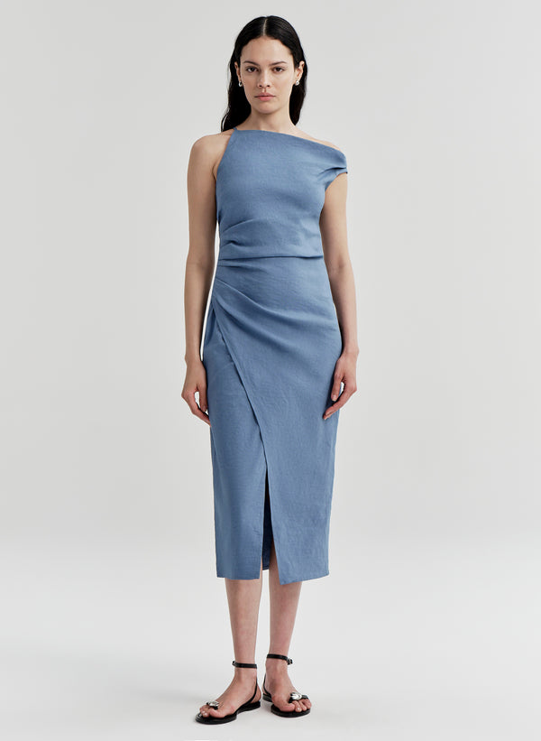 Woman wearing a blue one-shoulder dress on a light gray background