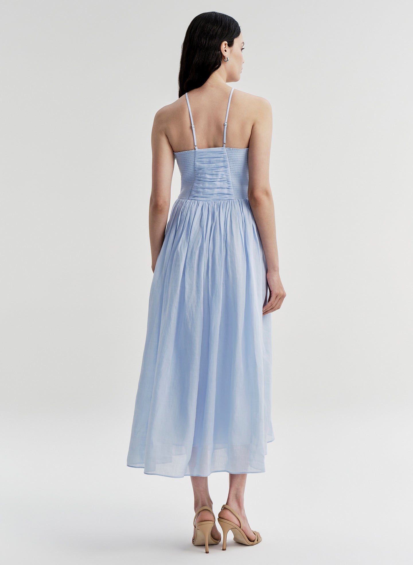 Woman wearing a light blue dress on a white background