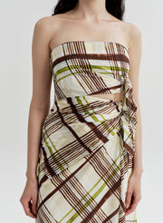 Woman wearing a cotton plaid strapless dress on a white background