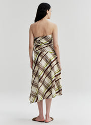 Woman wearing a cotton plaid strapless dress on a white background