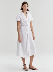 Woman wearing a white dress with a knot detail on a white background