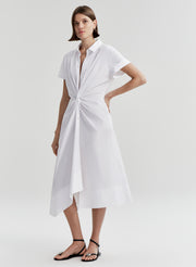 Woman wearing a white dress with a knot detail on a white background