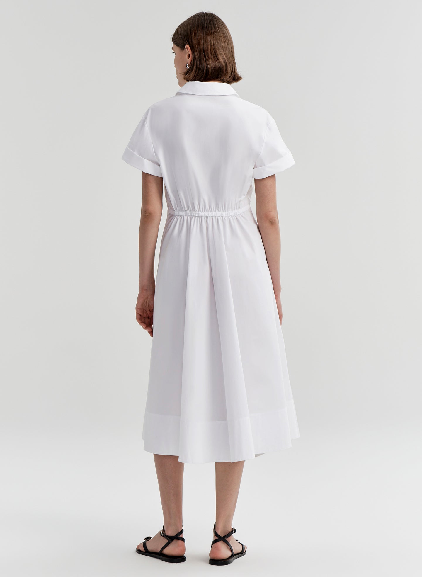 Woman wearing a white dress on a plain background
