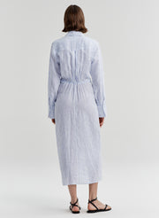 Woman wearing a blue and white striped dress on a plain background