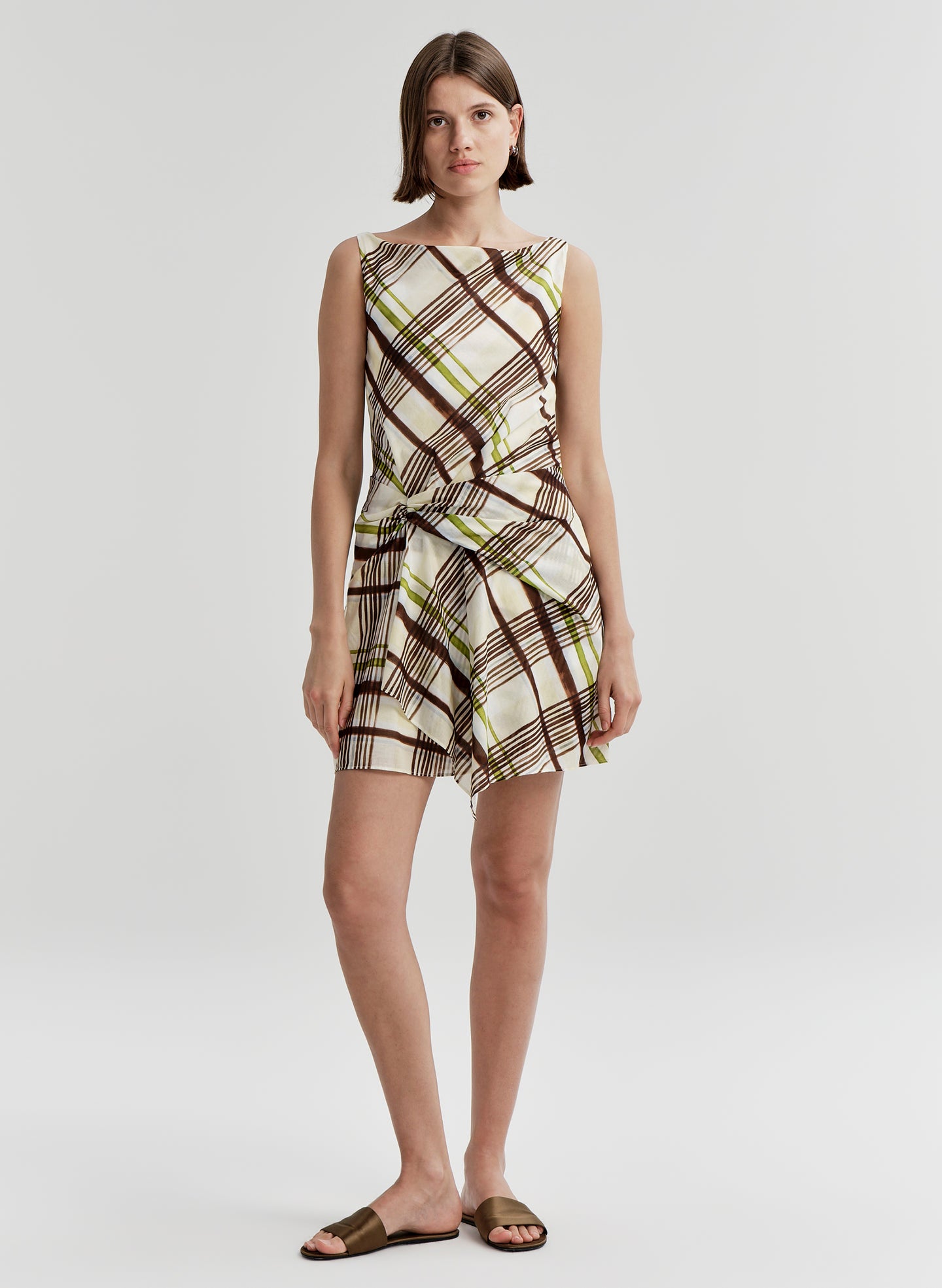 Woman wearing a plaid dress on a white background