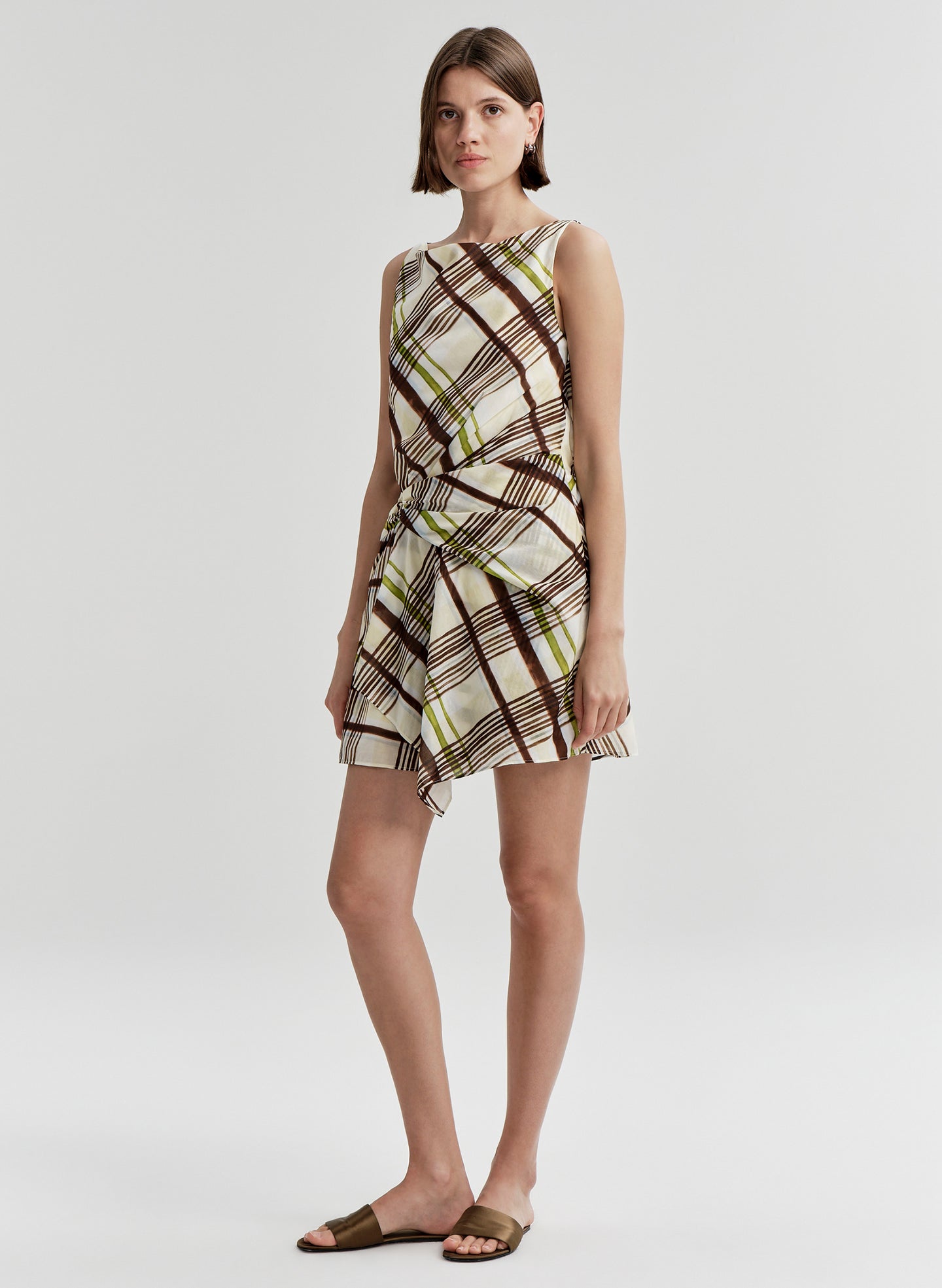Woman wearing a plaid dress on a white background