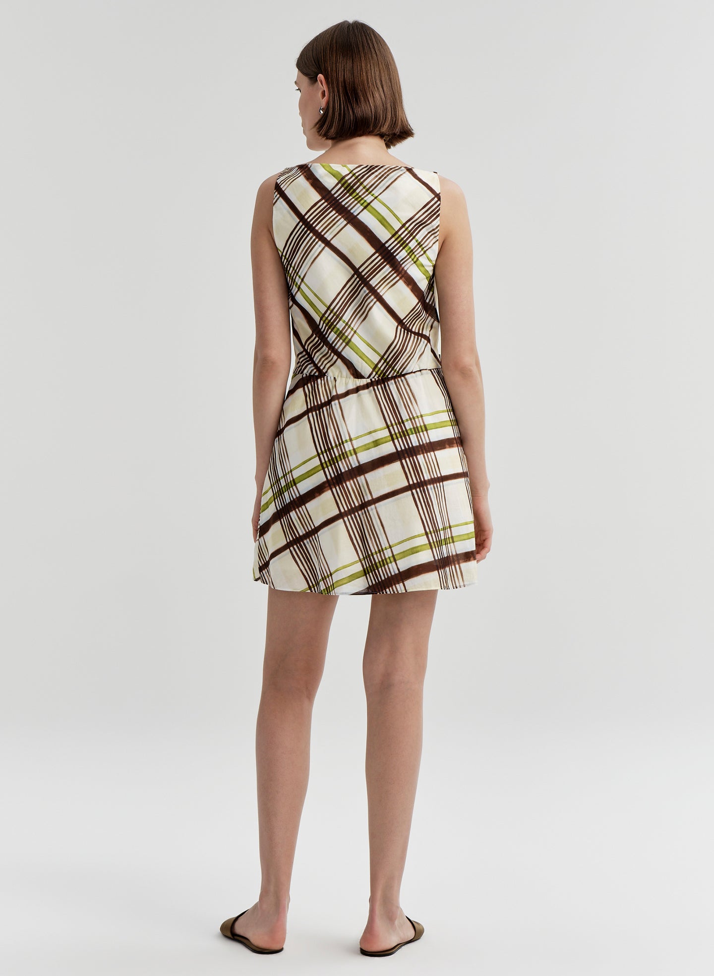Woman wearing a plaid dress on a white background