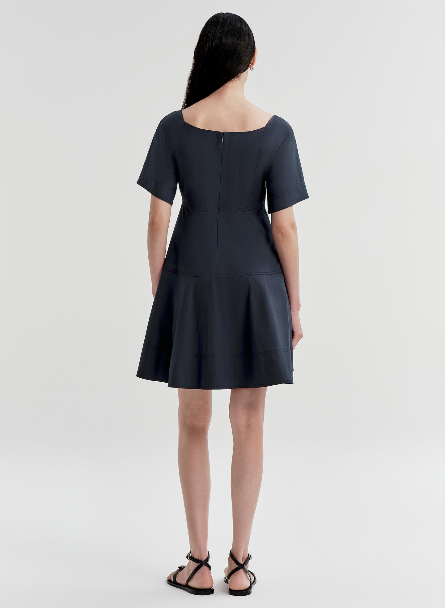 Woman wearing a dark blue dress on a white background