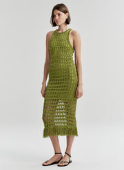 Woman wearing a green crochet dress on a white background