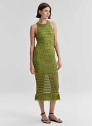 Woman wearing a green crochet dress on a white background