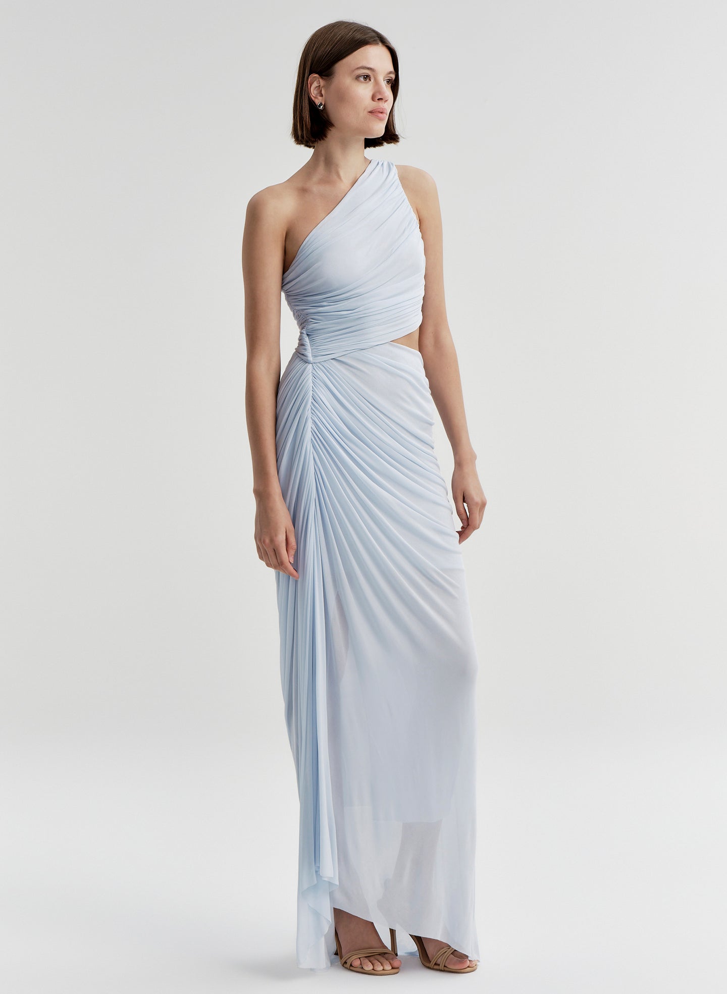 Woman wearing a light blue one-shoulder dress on a white background