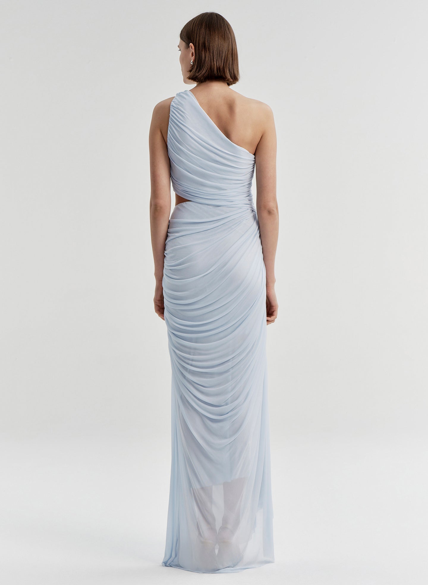 Woman wearing a light blue one-shoulder dress on a white background