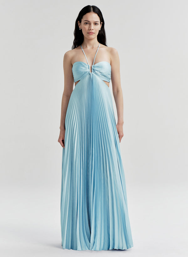 Woman wearing a light blue pleated gown on a white background