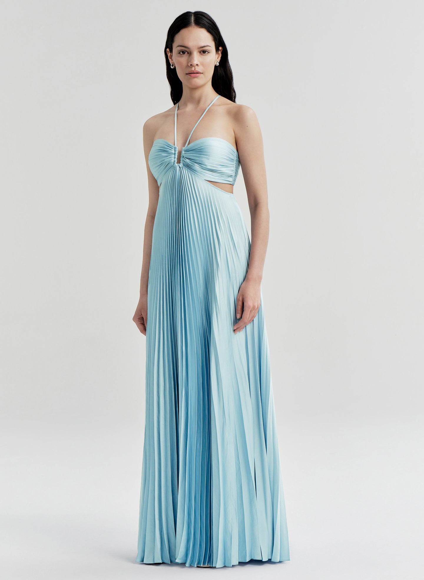 Woman wearing a light blue pleated dress on a white background