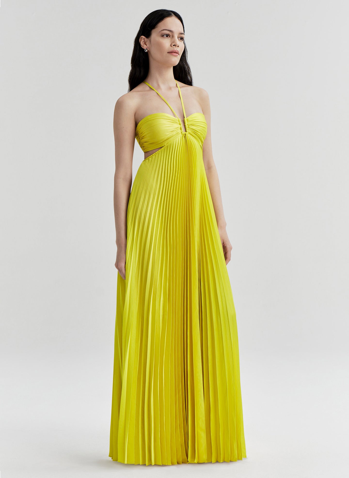 Woman wearing a yellow pleated dress on a white background