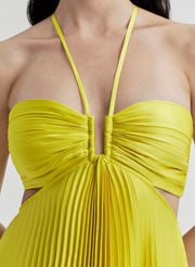 Yellow pleated dress with thin straps on a plain background