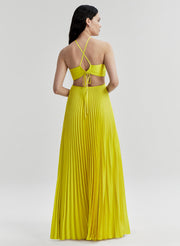 Woman wearing a yellow dress with thin straps on a light gray background