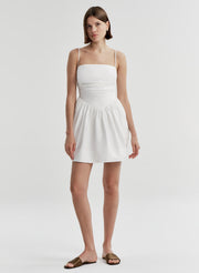Woman wearing a white dress on a plain background