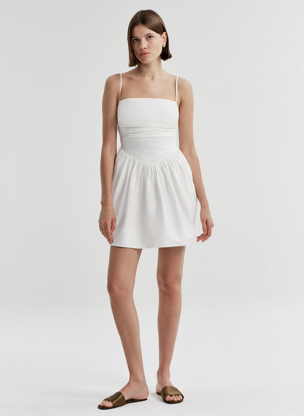 Woman wearing a white dress on a plain background