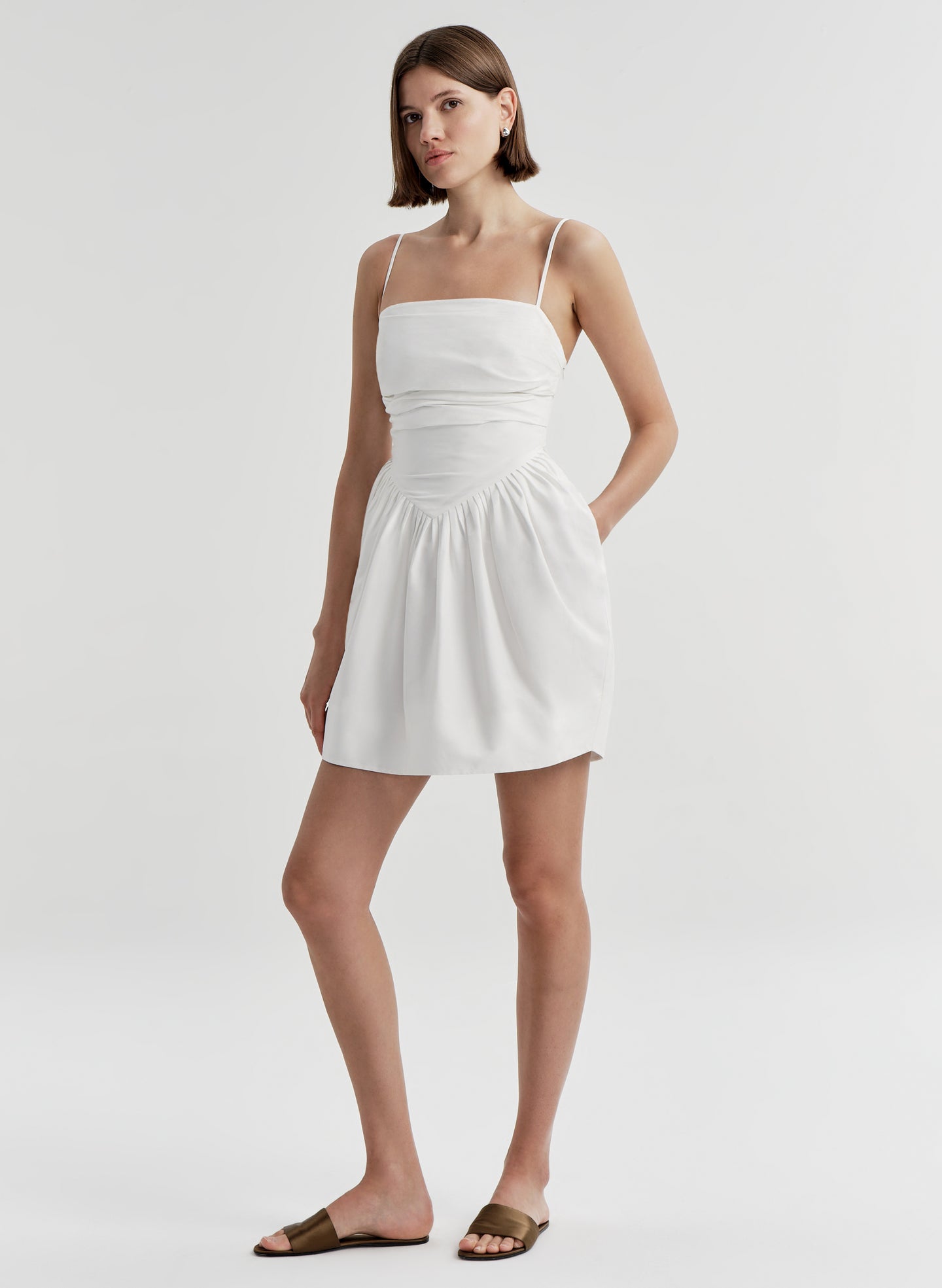 Woman wearing a white dress on a plain background