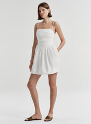 Woman wearing a white dress on a plain background