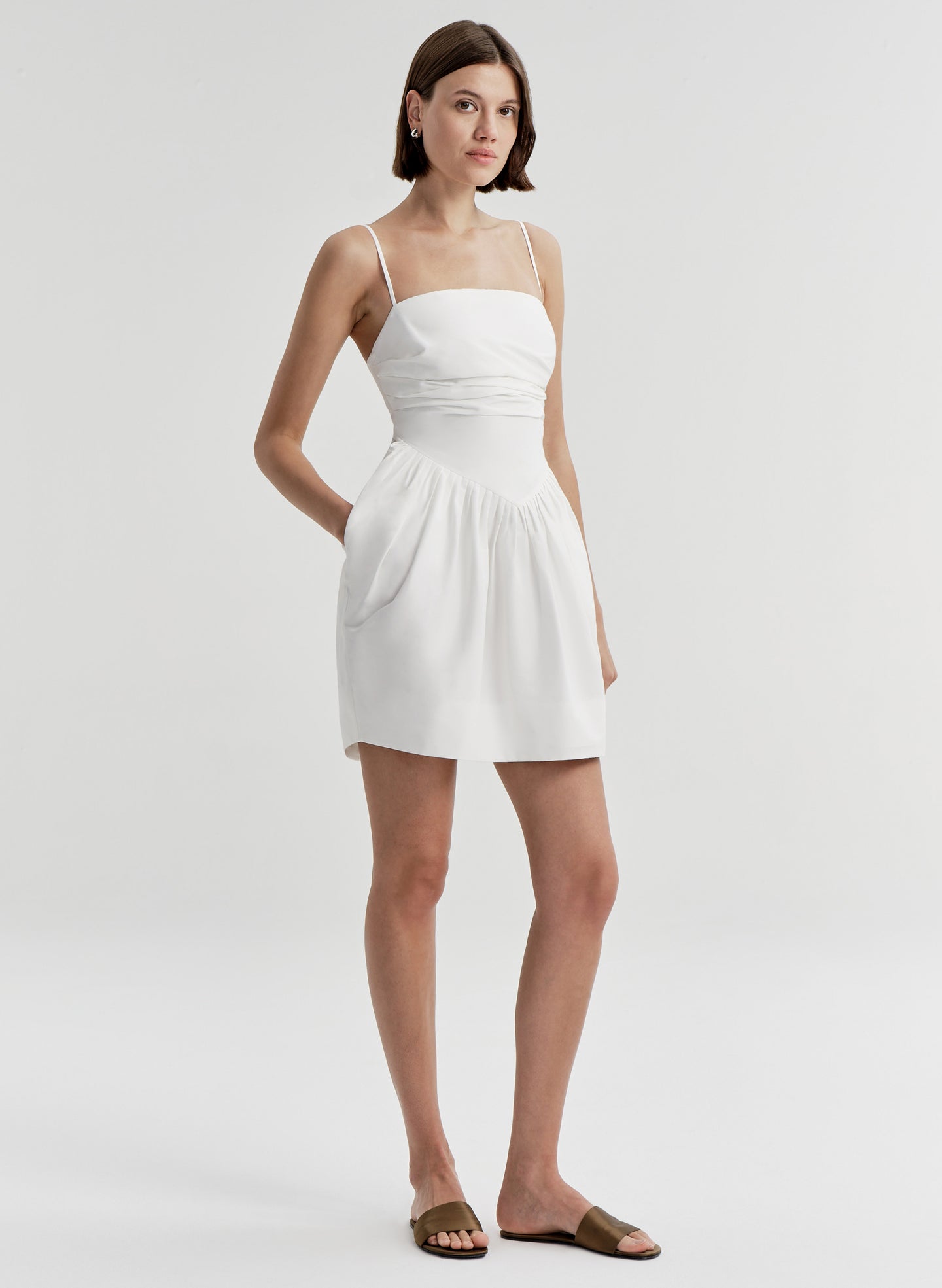 Woman wearing a white dress on a plain background