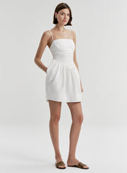 Woman wearing a white dress on a plain background