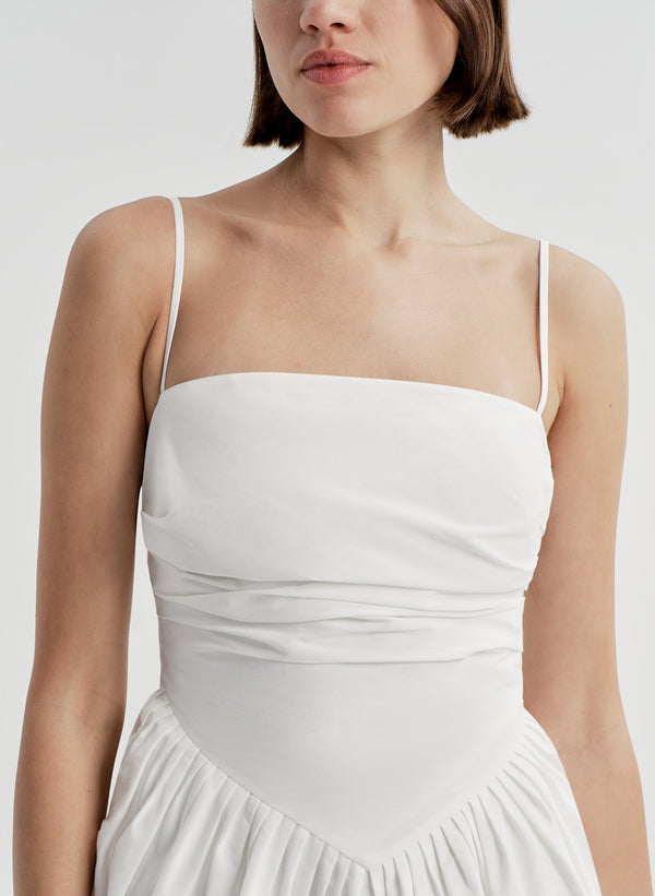 Woman wearing a white dress on a plain background