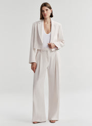 Woman wearing cream colored linen pants with a matching jacket 