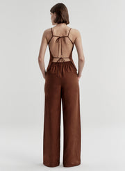 Woman wearing a brown top with open back on a white background