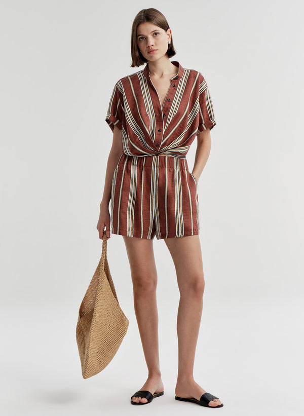 Woman wearing striped linen shorts with a matching top on a white background
