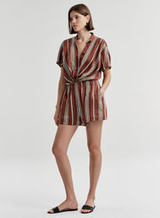 Woman wearing striped linen shorts with a matching top on a white background
