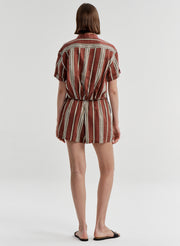 Woman wearing striped linen shorts with a matching top on a white background