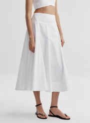 Woman wearing a white skirt with a white background 