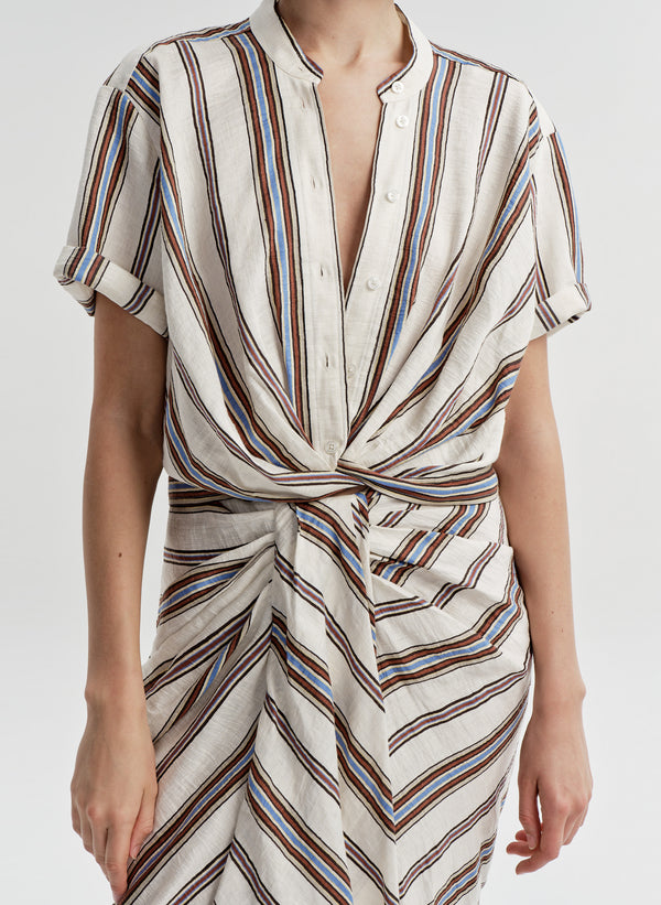 Woman wearing a striped linen top with a matching skirt and a plain background