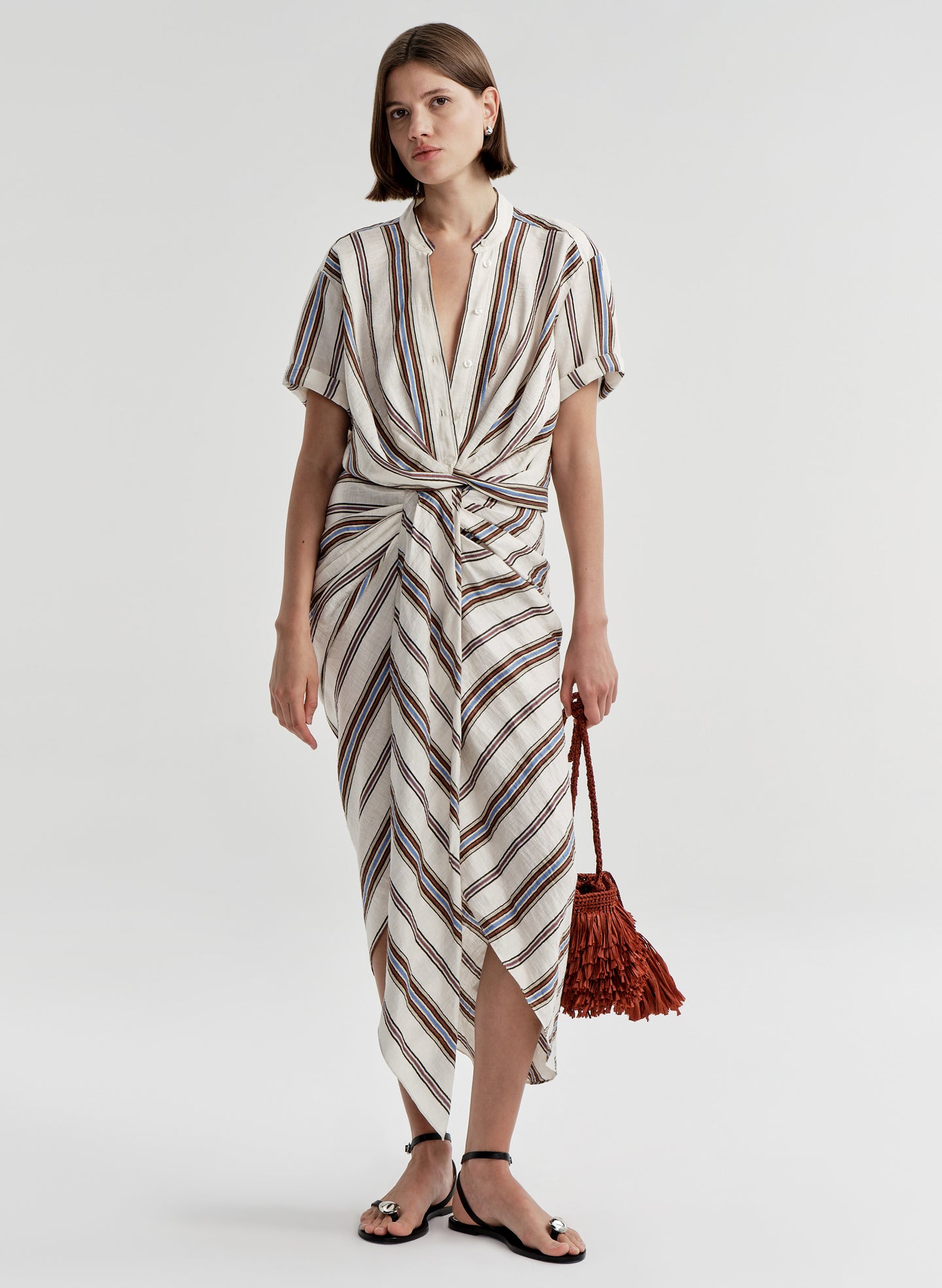 Woman wearing a striped linen skirt with a matching top on a plain background