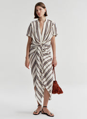 Woman wearing a striped linen skirt with a matching top on a plain background