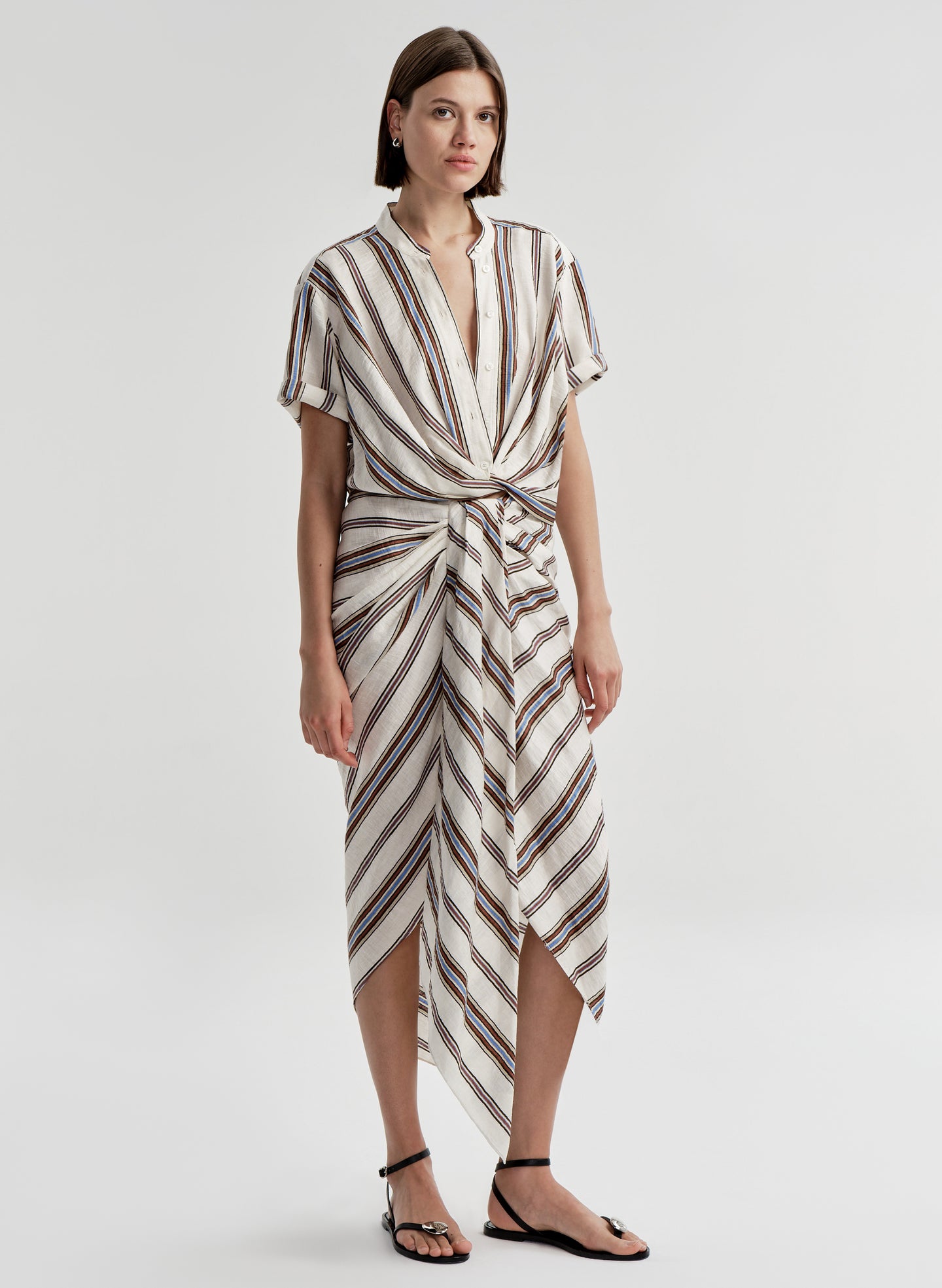 Woman wearing a striped linen skirt with a matching top on a plain background