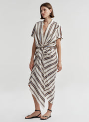 Woman wearing a striped linen skirt with a matching top on a plain background