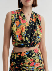 Woman wearing a sleeveless floral top with a matching skirt on a white background