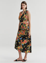 Woman wearing a sleeveless floral top with a matching skirt on a white background