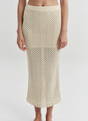Beige knitted skirt worn by a woman on a white background
