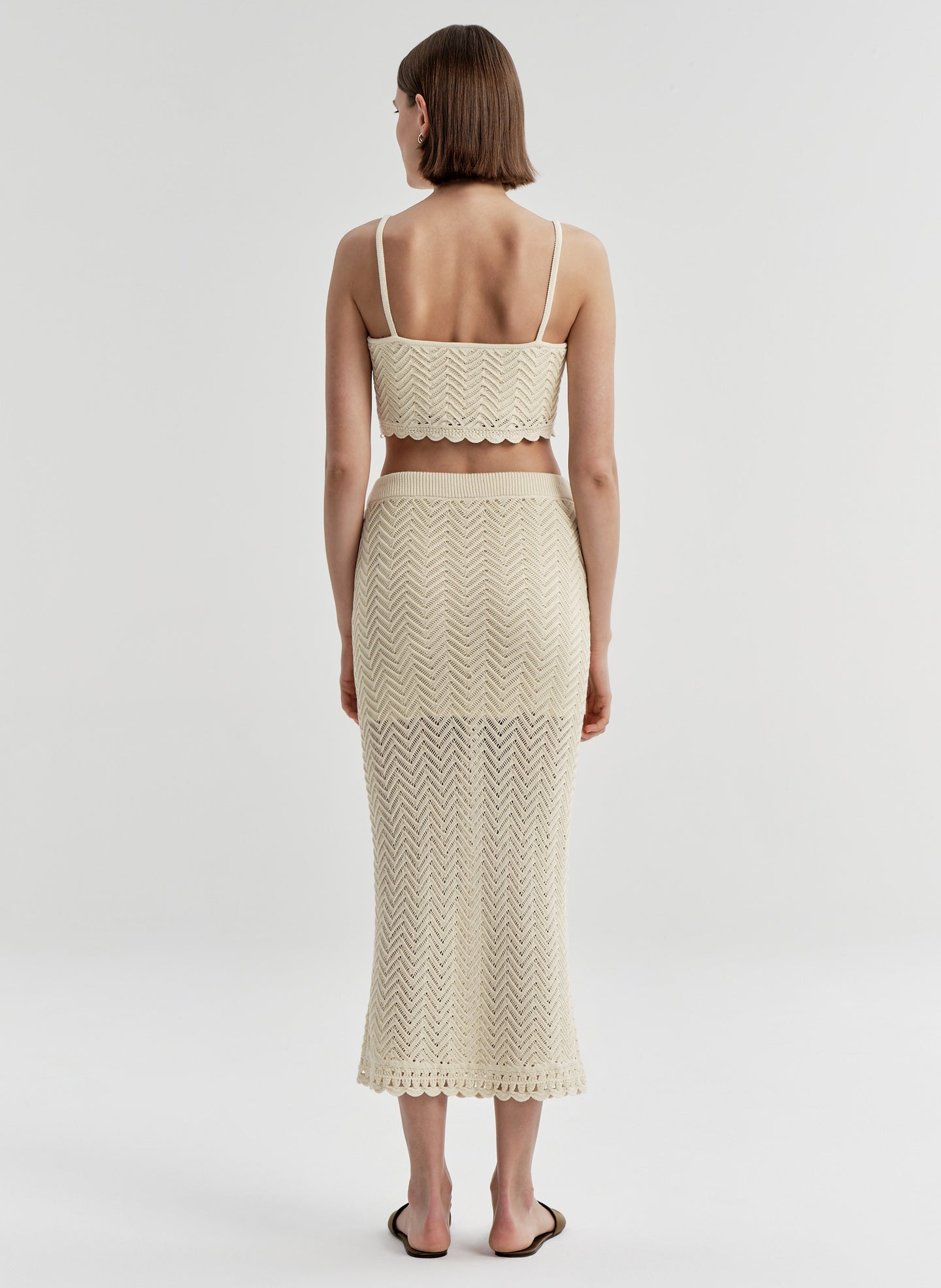 Woman wearing a beige crochet skirt and matching top 