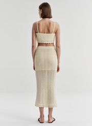 Woman wearing a beige crochet skirt and matching top 