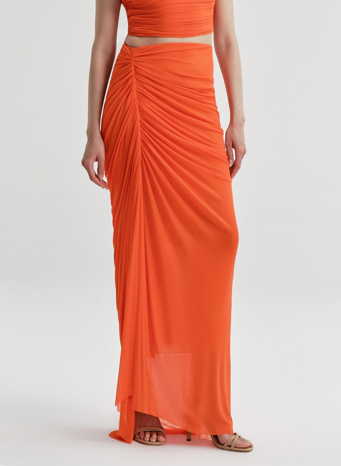 Orange two-piece outfit with a top and flowing skirt on a white background