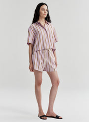 Woman wearing a striped shirt and shorts set on a white background