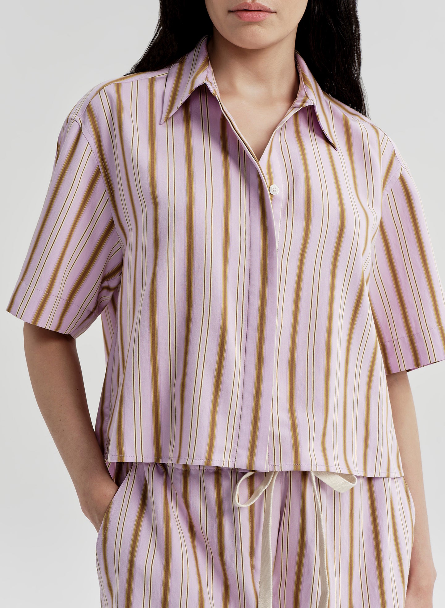 Person wearing a striped shirt and pants set on a plain background