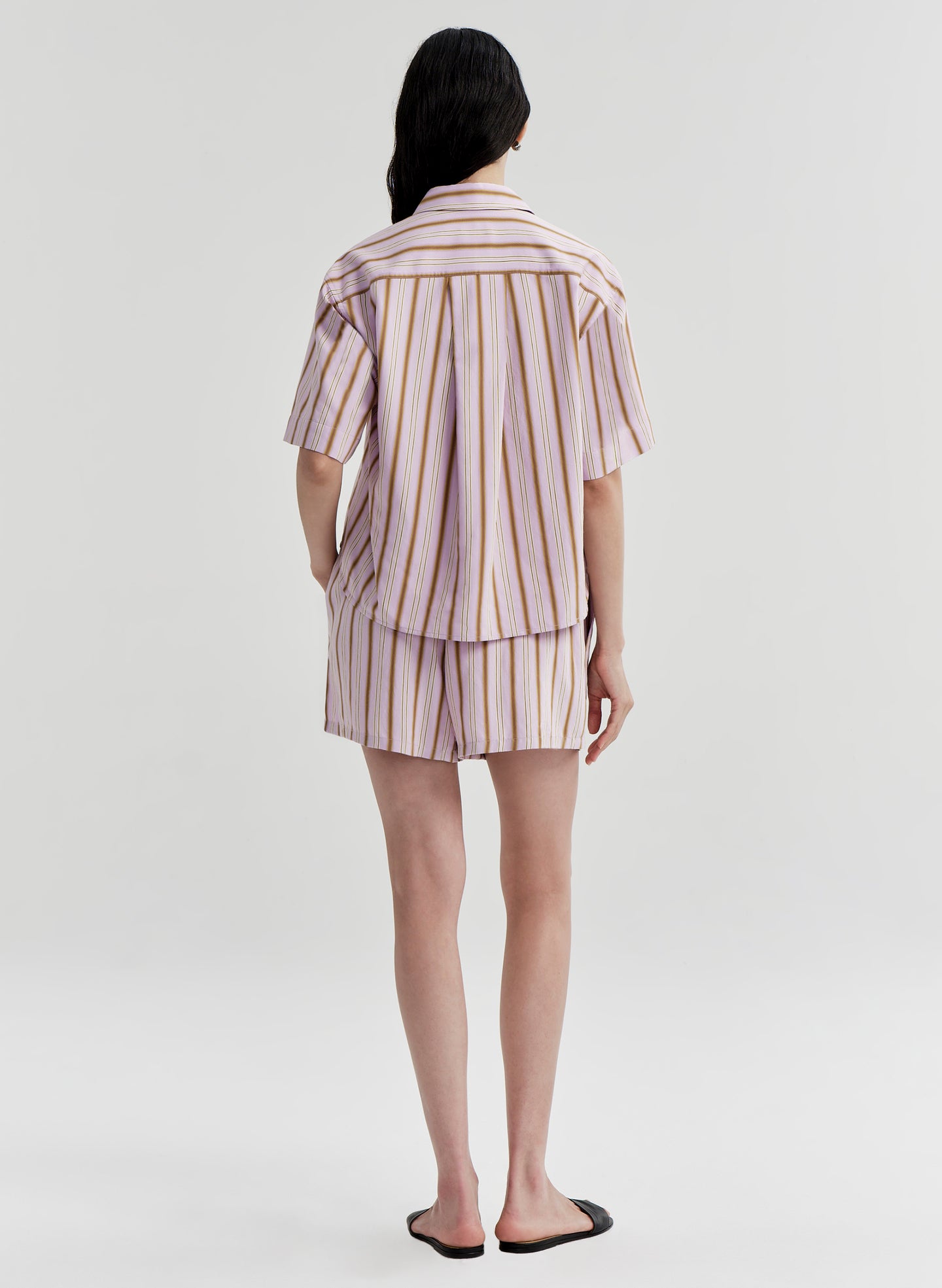 Person wearing a striped shirt and shorts set on a white background