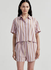 Woman wearing a striped shirt and shorts set on a plain background